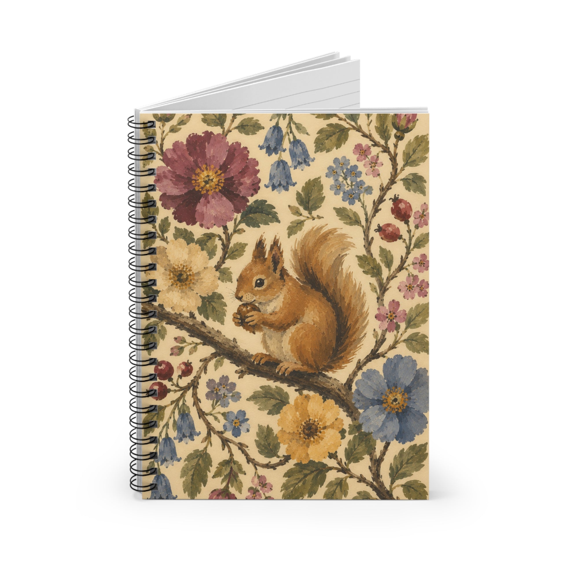 A notebook partially open and standing on a white background with a squirrel on a branch surrounded by vines and flowers