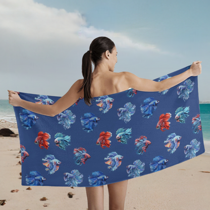 Woman spreading betta fish printed towel behind her on the beach