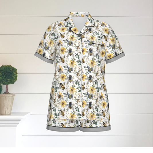 Two piece short pajama set with bees and flowers all-over print. The edges of the sleeves and shorts have gray trim.